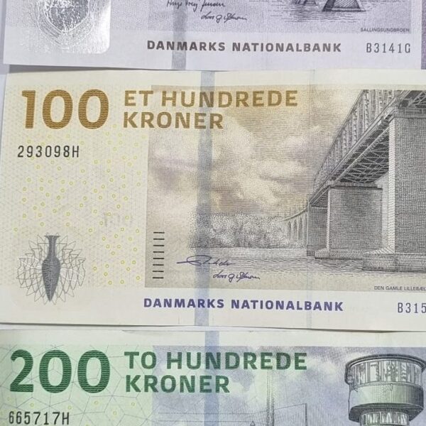 Danish kroner banknotes in multiple denominations arranged in a layered layout. Danish kroner banknotes in multiple denominations arranged in a layered layout.