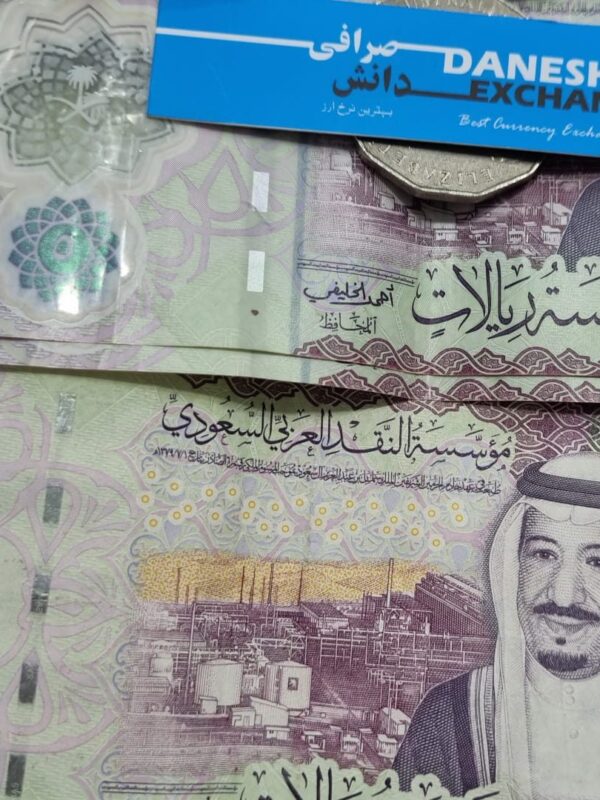 Saudi Arabian 5‑riyal banknotes and arranged together with a Danesh Exchange card. Saudi Arabian 5‑riyal banknotes and arranged together with a Danesh Exchange card.