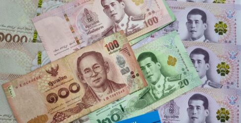 Thai baht banknotes in 20, 100, 500, and 1000 denominations arranged together with a Danesh Exchange card at the bottom. Thai baht banknotes in 20, 100, 500, and 1000 denominations arranged together with a Danesh Exchange card at the bottom.