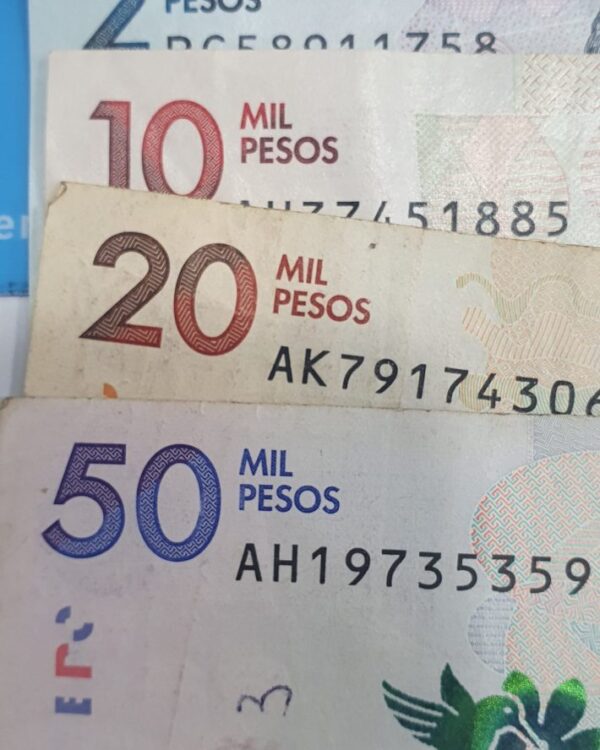 Colombian peso notes in 2k, 10k, 20k, and 50k denominations arranged together with Danesh Exchange signage. Colombian peso notes in 2k, 10k, 20k, and 50k denominations arranged together with Danesh Exchange signage.
