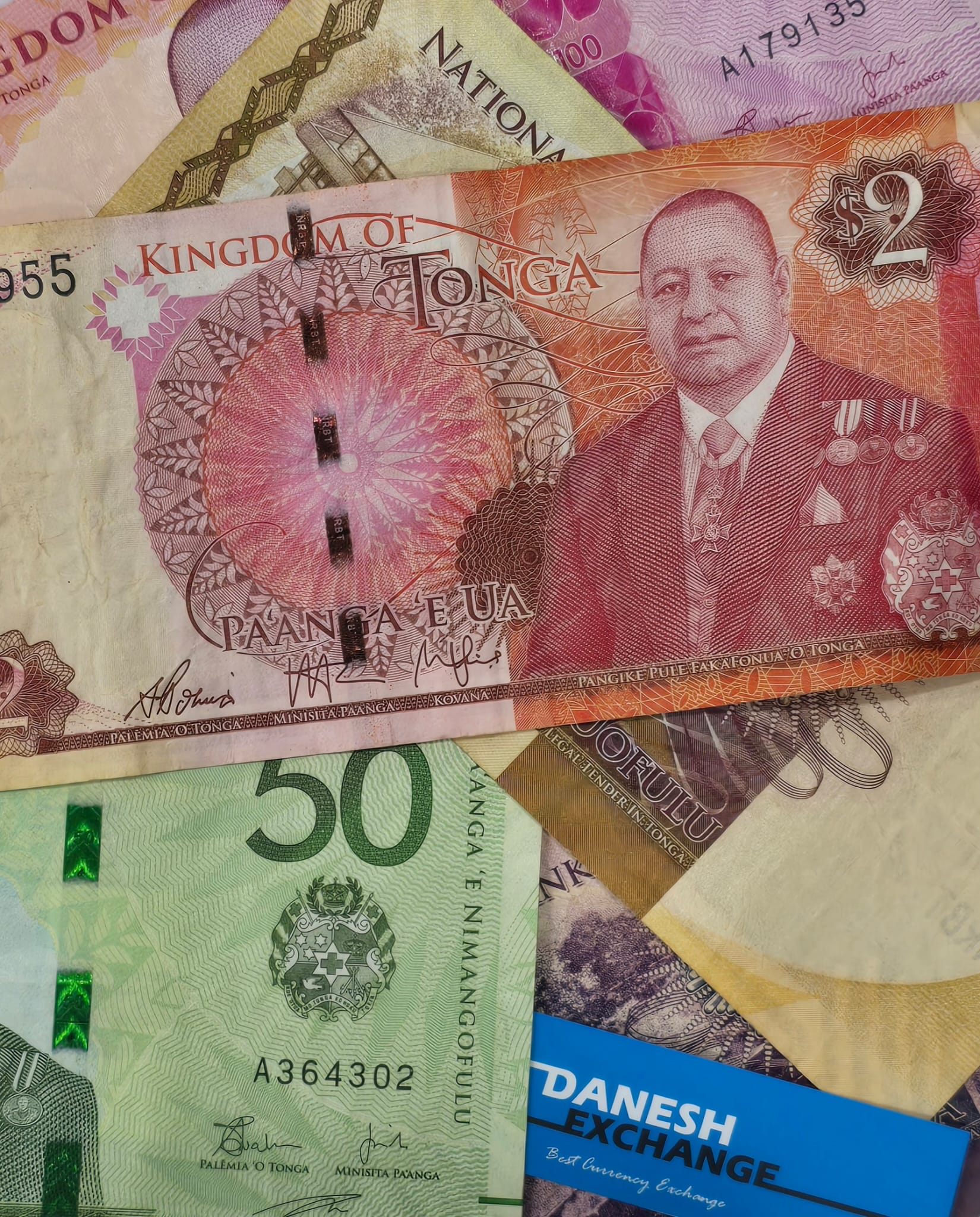 Collection of Tongan banknotes in multiple denominations alongside Danesh Exchange card. Collection of Tongan banknotes in multiple denominations alongside Danesh Exchange card.