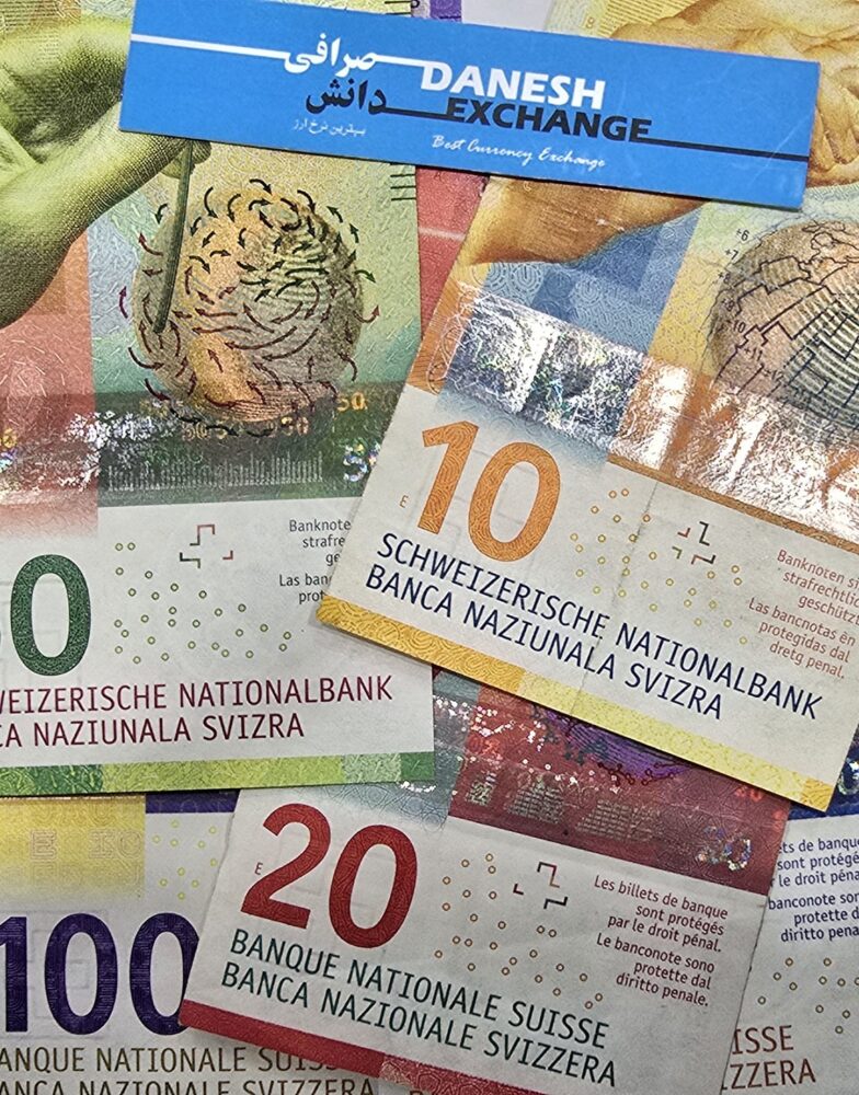 Swiss franc banknotes in 10, 20, 50, and 100 denominations arranged together with a Danesh Exchange card placed on top. Swiss franc banknotes in 10, 20, 50, and 100 denominations arranged together with a Danesh Exchange card placed on top.