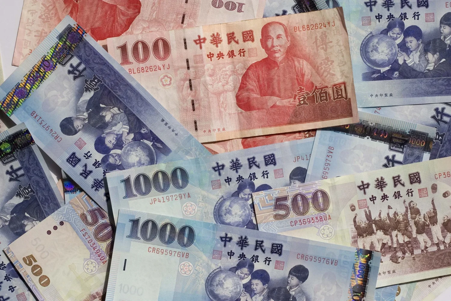 Collection of Taiwanese banknotes in multiple denominations scattered. Collection of Taiwanese banknotes in multiple denominations scattered.