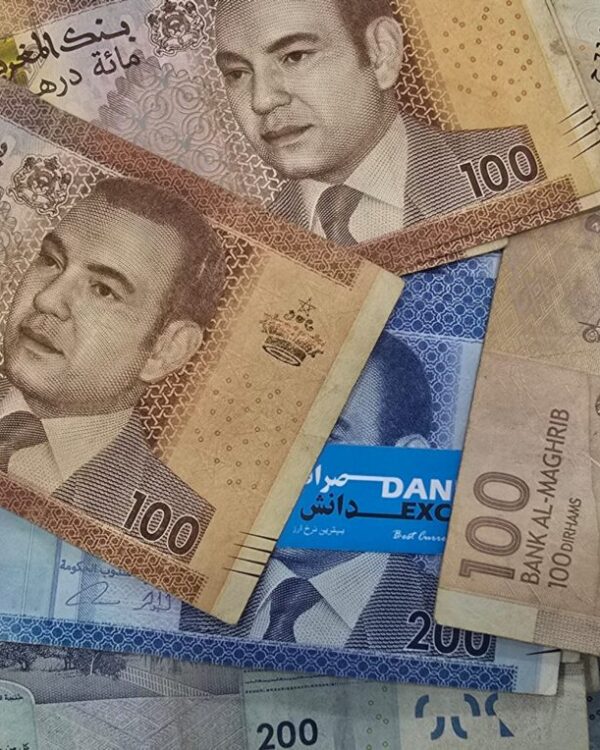 Moroccan banknotes in 100 and 200 dirham denominations arranged together, featuring King Mohammed VI and intricate geometric designs. Moroccan banknotes in 100 and 200 dirham denominations arranged together, featuring King Mohammed VI and intricate geometric designs.